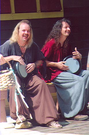 two drummers play on stage, laughing